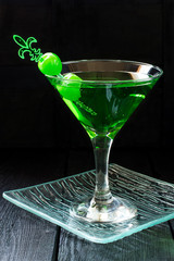Green cocktail with maraschino cherry in a martini glasses