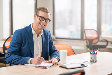 Positive man sitting at the table 