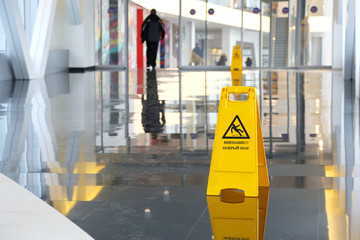 Yellow warning sign wet floor in Russian language