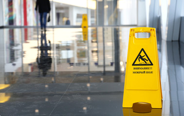 Yellow warning sign wet floor in Russian language
