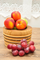 Apples, nectarines and grapes displayed in a wooden bowl