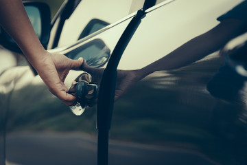 Male open the door caHand on handle. Close-up of man hand opening a car door. vintage picture style...