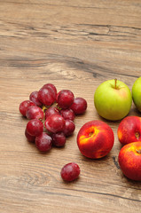 Apples, nectarines and grapes displayed on a wooden background