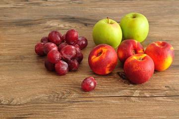 Apples, nectarines and grapes displayed on a wooden background