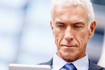 Senior businessman holding touchpad 