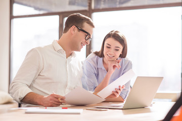 Positive colleagues sitting at the table     