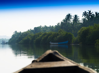 In Indian boat swimming down the jungle river background