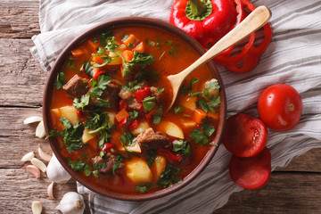 Traditional Hungarian goulash soup bogracs close-up in a bowl. Horizontal top view
