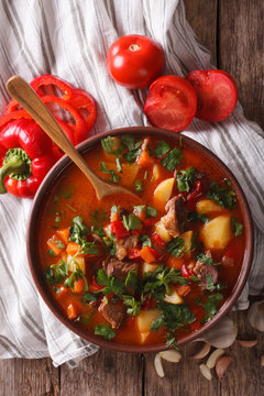 Traditional Hungarian goulash soup bogracs close-up in a bowl. Vertical top view

