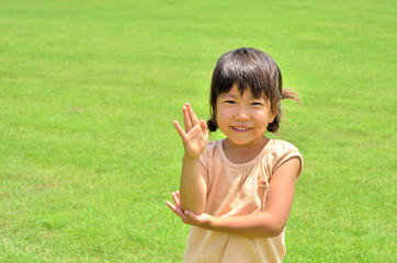 芝生広場で笑う女の子