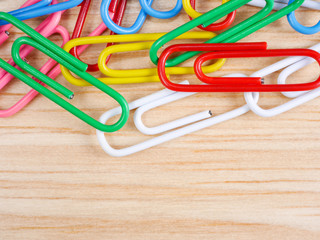 Close up colorful paper clip on wood background (Business object)