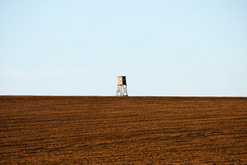 Hunting lookout in a field on the horizon