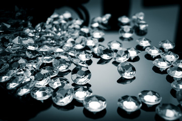 Black and white image of diamonds scattered on a shiny surface