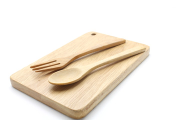 wooden spoon and wooden fork on cutting board.
