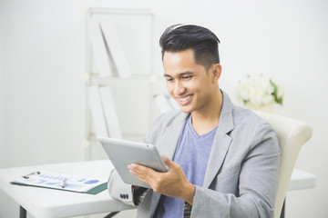 Obraz na płótnie Canvas asian man using tablet pc