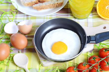 Fried egg, toast bread, fresh juice, tomatoes and oranges