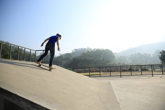 young woman skateboarder skateboarding at skate park