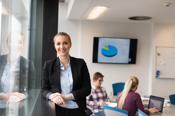 portrait of young business woman at office with team on meeting