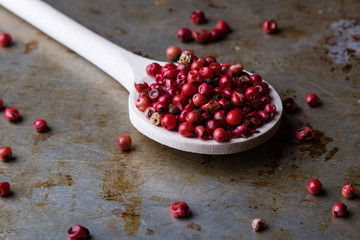 red peppercorn seeds on steel plate