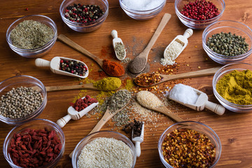 diferent color spices on wooden table