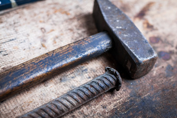 Hammer and nail on wooden plank