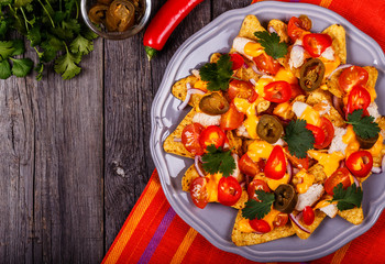 Nachos with melted cheese sauce, jalapeno, chicken and vegetable