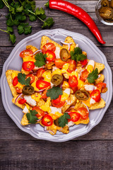 Nachos with melted cheese sauce, jalapeno, chicken and vegetable
