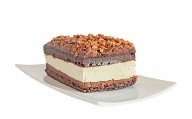Chocolate cake with hazelnut and white cream, nuts, white plate
