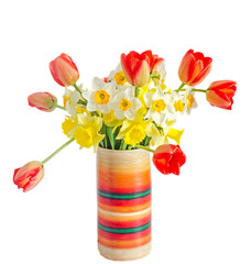Yellow and white daffodils flowers, red orange tulips in a multi colored vase