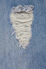 Fototapeta na wymiar Blue jeans background closeup view to torn texture.