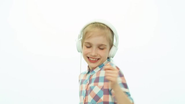 Closeup portrait girl 7-8 years old listening music on the white background