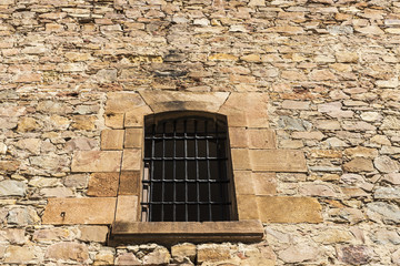 Fototapeta na wymiar Old stone wall with a latticed window