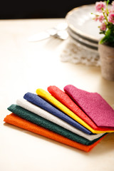 Colorful paper table napkins, flowers and plates
