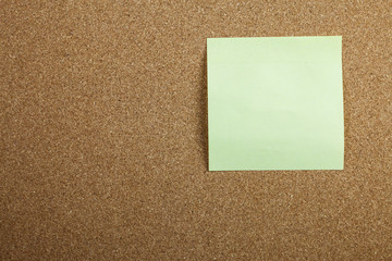 Yellow sticky note on cork board