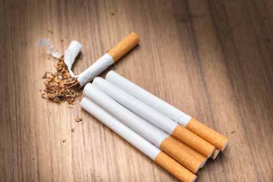 Tobacco  cigarette detrimental on wood background ,select focus front
