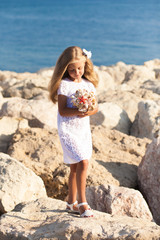 Beautiful girl standing on rocky seashore