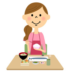 ご飯を食べるエプロンの女性