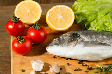 Fresh uncooked dorado or sea bream fish with lemon