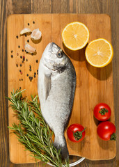 Fresh uncooked dorado or sea bream fish with lemon