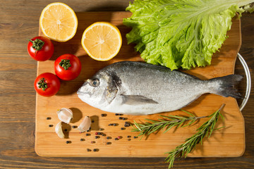 Fresh uncooked dorado or sea bream fish with lemon