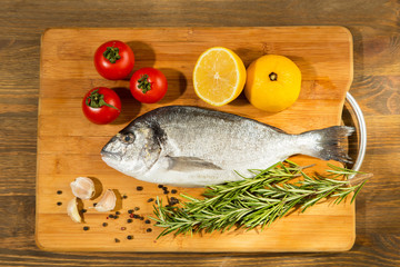 Fresh uncooked dorado or sea bream fish with lemon