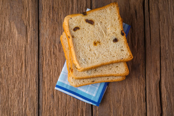 Sweet bread with cinnamon and raisins for dessert on the wood table