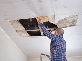 Man repairing collapsed ceiling. - 108801764