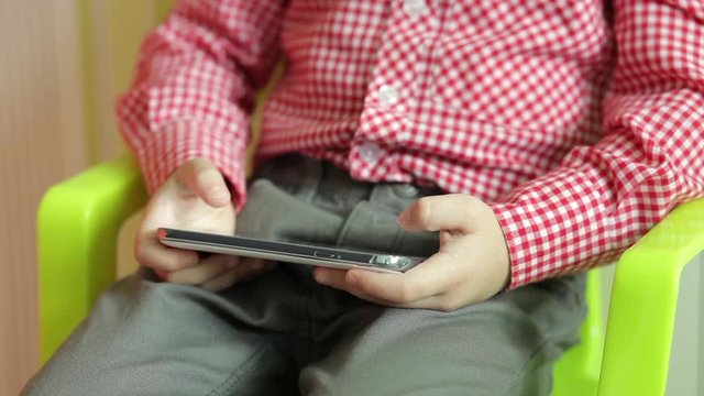 Small child touching the screen of smartphone as if playing or searching something.