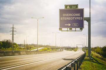 Empty highway and traffic sign above it. Text Overcome Stereotypes - appeal to avoid stereotypes,...