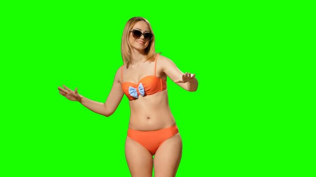Girl dancing in a swimsuit on the green alpha