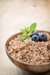 Buckwheat porridge in a bowl with mint leaves and blueberries.