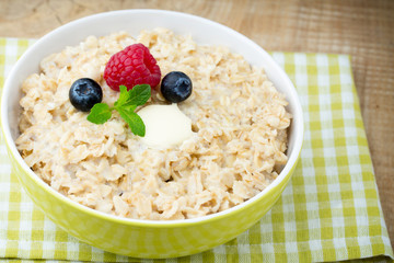 Oatmeal porridge in bowl with berries raspberries and blackberri