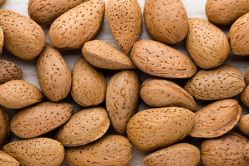 Group of almond nuts with leaves.Wooden background.