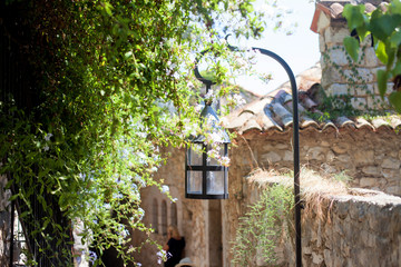Street lamp in a village in France with a green tree on the othe